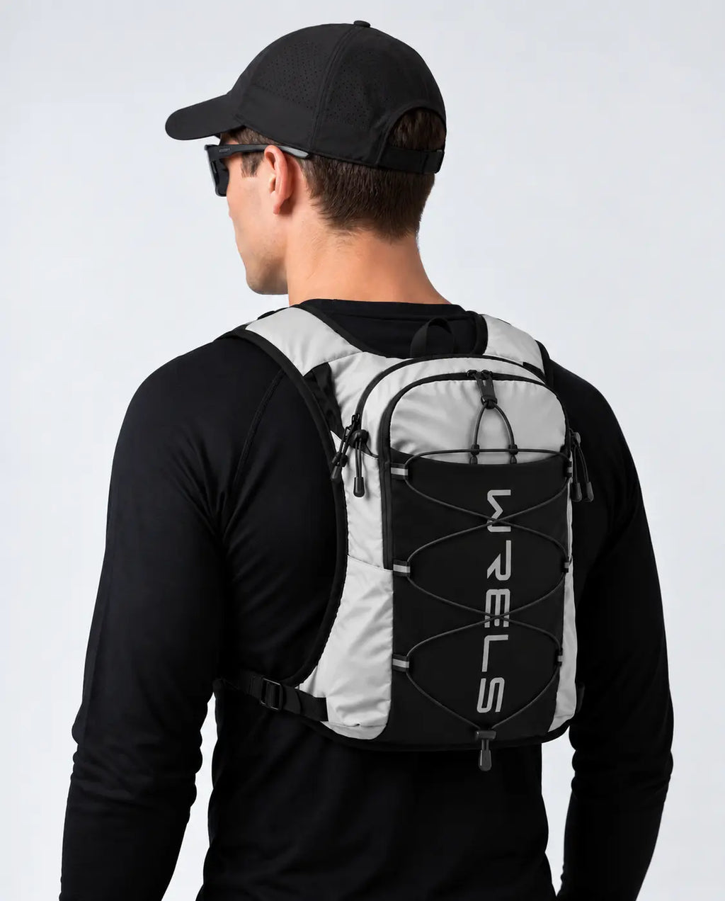 sac trail 10L multi-points de couleur gris porté par un homme avec une casquette vue de dos 