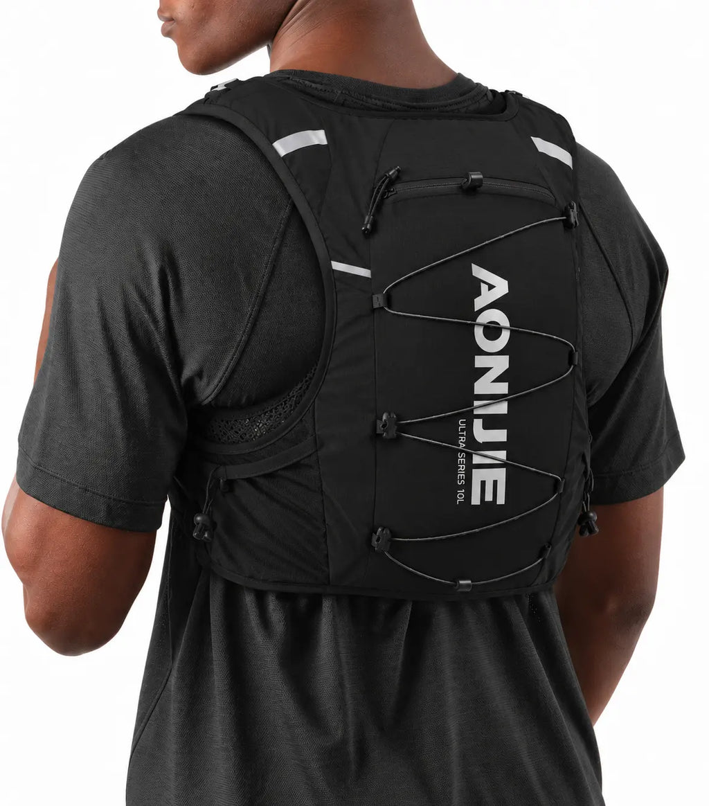 sac trail 10L porte baton de couleur noir porté sur un homme dvu de derriere de 3/4