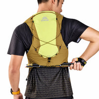 sac ultra trail 12L de couleur jaune porté par un homme attrapants ses batons a l'arriere de son sac 
